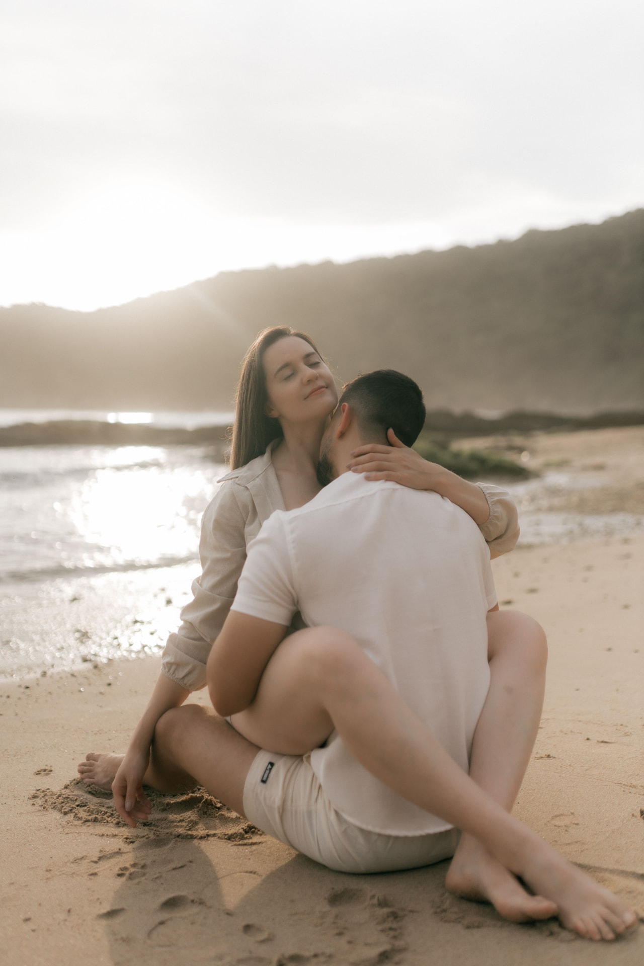 Newlywed couple on a golden beach at sunrise on their East African honeymoon