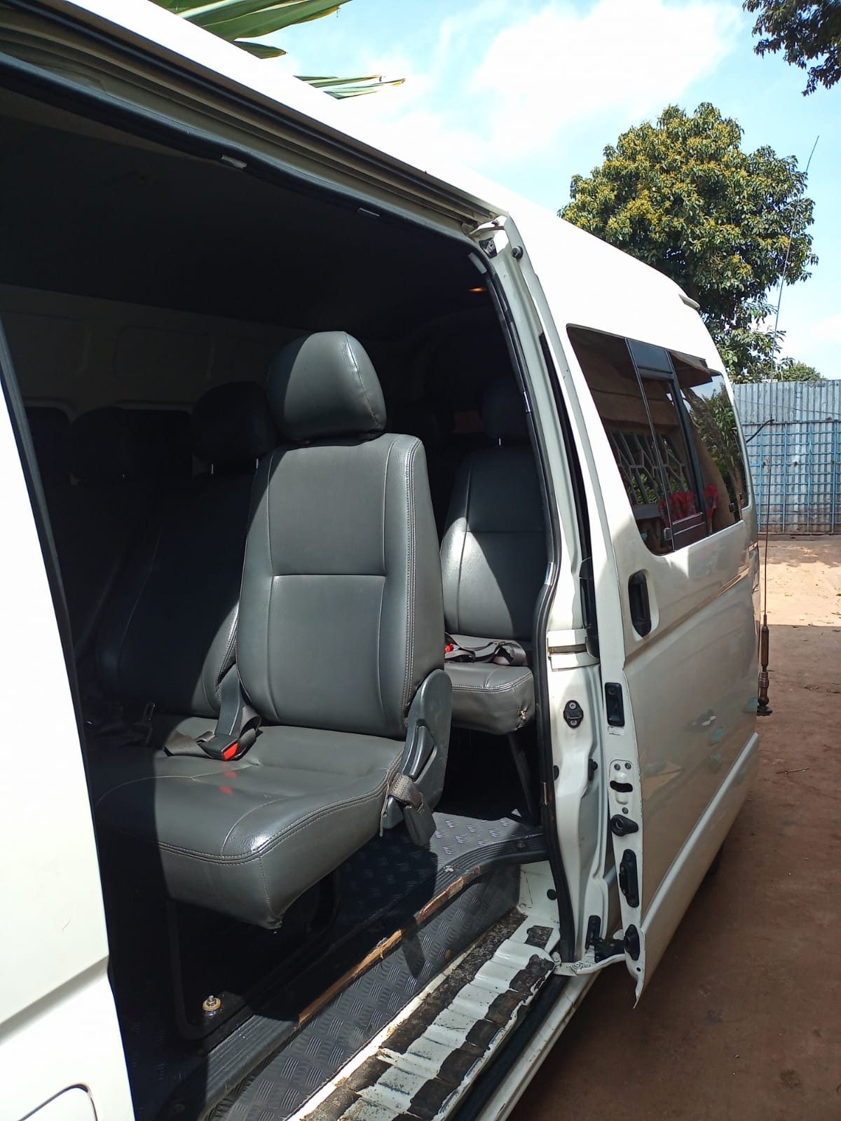 Open sliding door of the tourist van showing leather captain seats