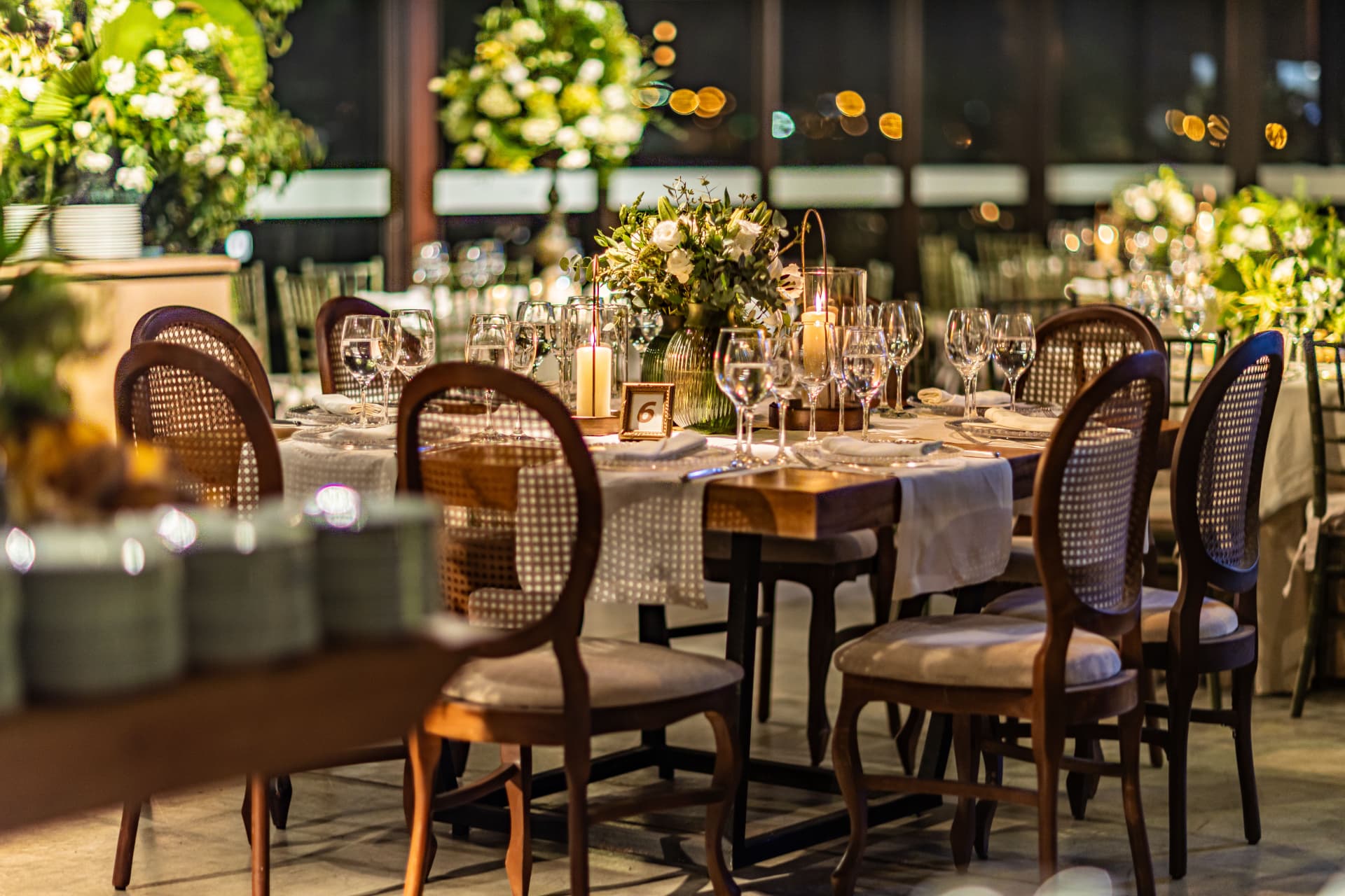 Candlelit dinner tables with floral centrepieces