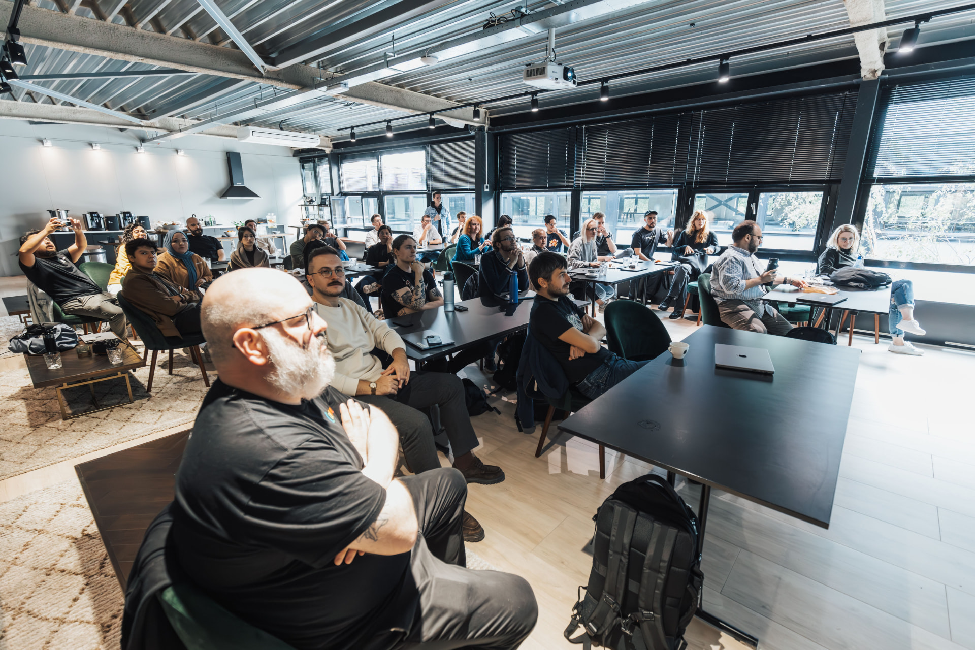 Delegates seated in a bright conference room watching a presentation