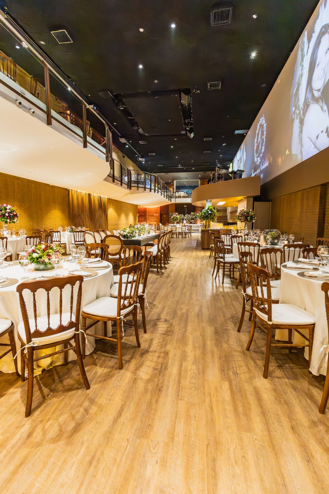 Banquet hall set with round tables and stage projection
