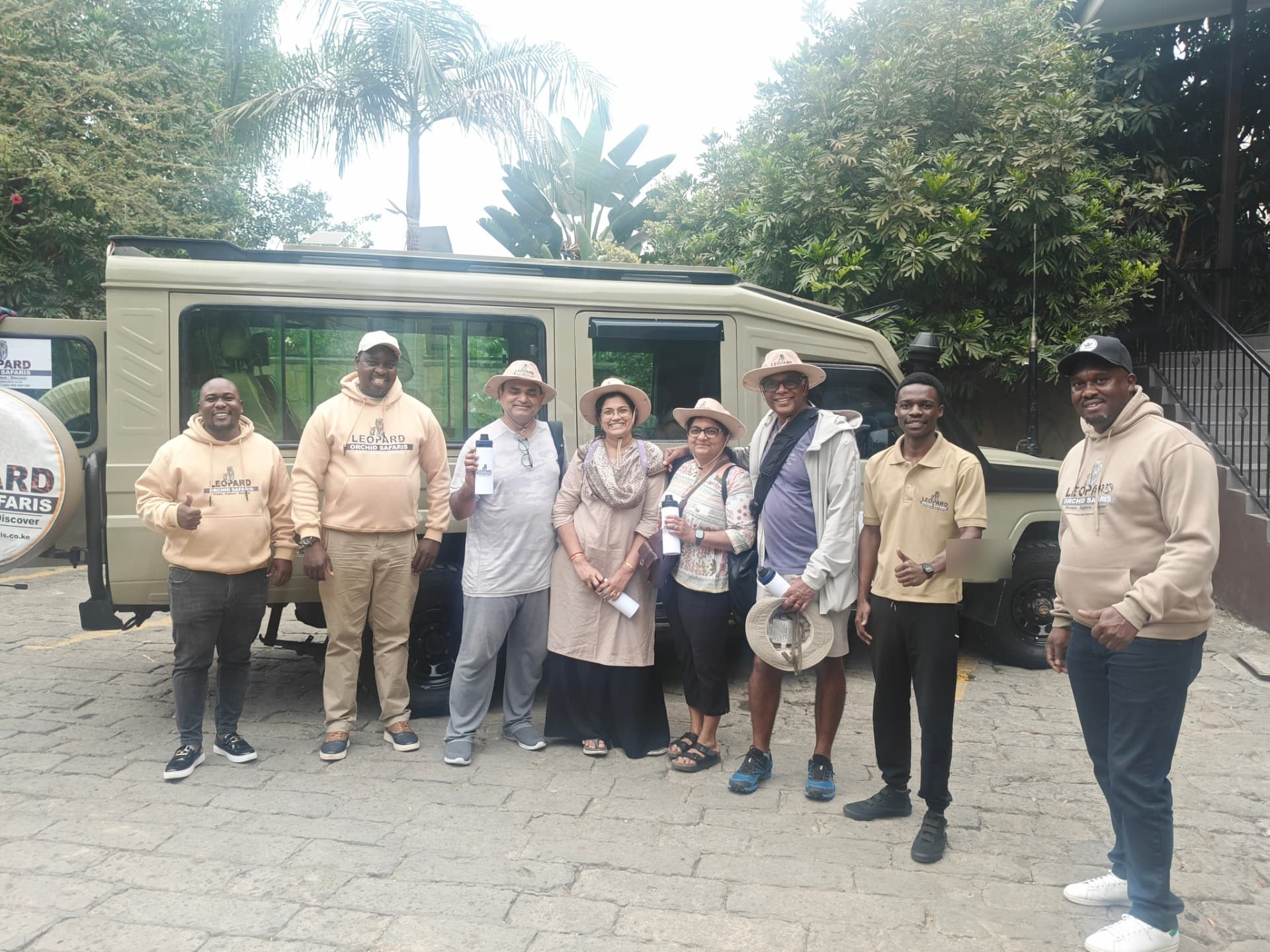 Guests with our director and guides beside a branded Land Cruiser